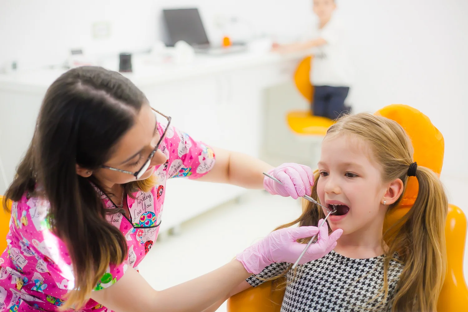 O fată stă pe scaun portocaliu în cabinet.